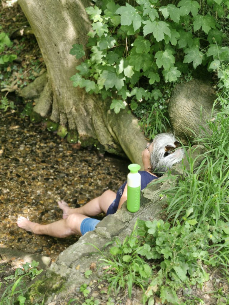 Vrouw die vanuit ontspanning met de voeten in het water zit, wat haar ervaring in een beeld samenvat